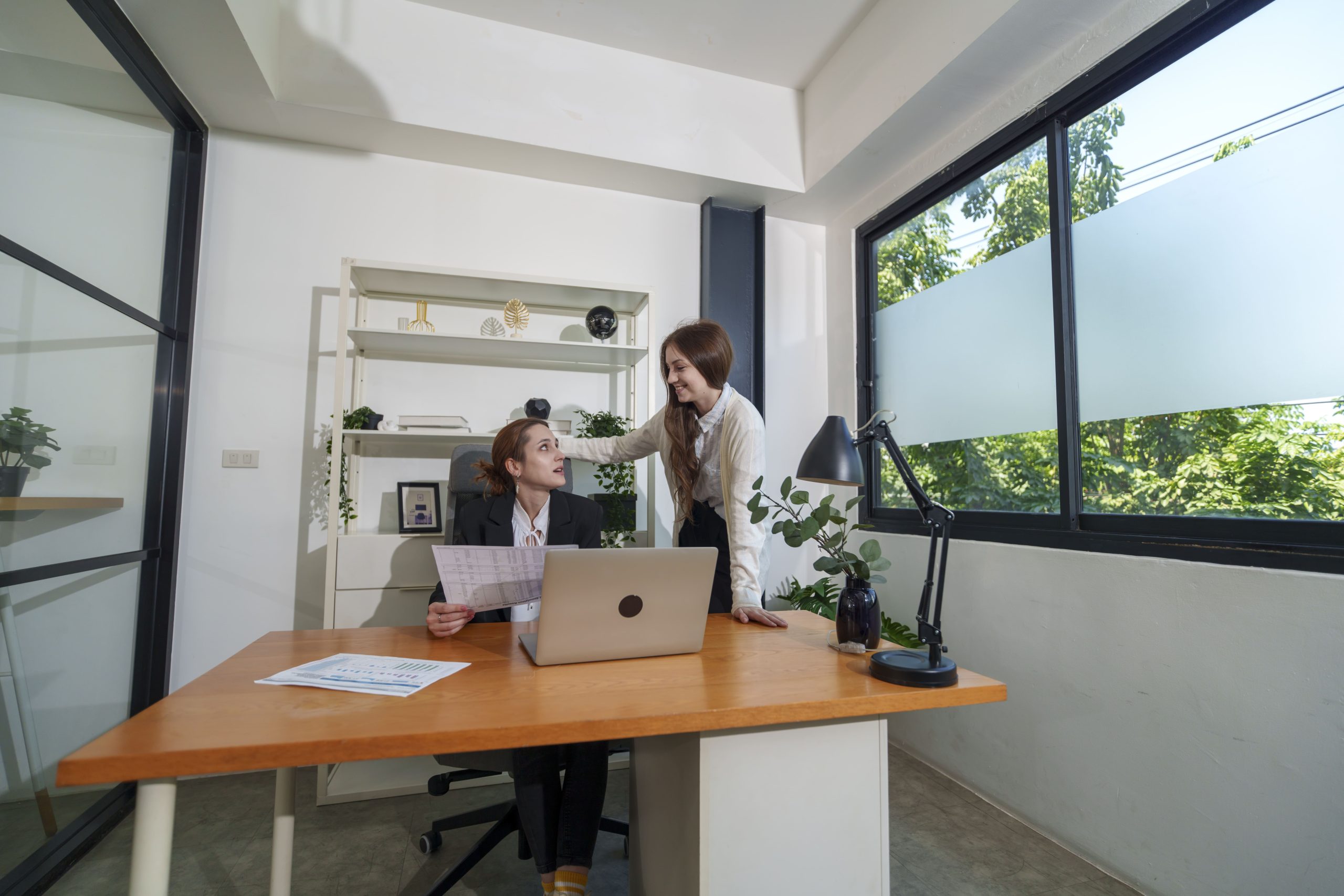 Dos profesionales colaborando en una oficina moderna, simbolizando el trabajo en equipo y la asesoría en trámites de extranjería.
